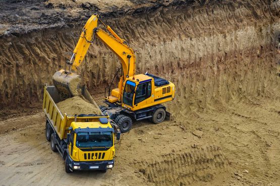 Bagger belädt einen LKW mit Erdaushub